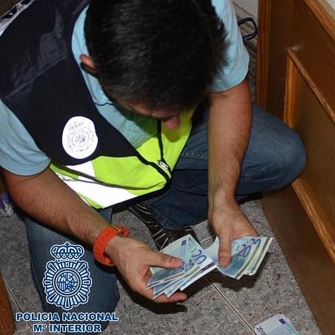 Un agente cuenta los billetes intervenidos. 