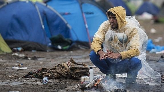 Un inmigrante calienta sus manos en medio de un campo cerca a Roszke, 180 kilómetros sureste de Budapest.