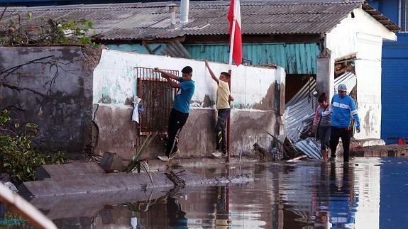 Un grupo de niños intentan cruzar una calle inundada en Chile. 