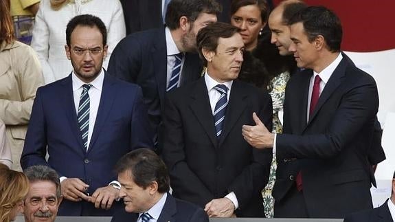 Rafael Hernando (c.) charla con Pedro Sánchez durante el desfile militar. 