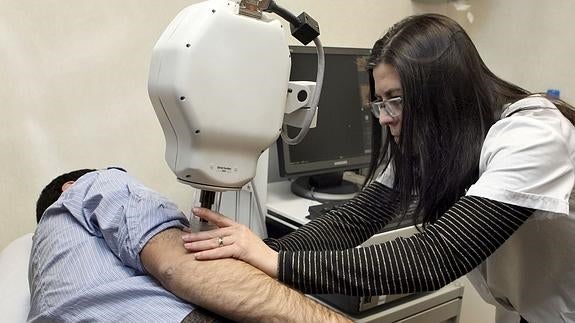 Una doctora examina los lunares de un paciente.