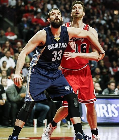 Marc Gasol (i) y Pau Gasol observan la pelota. 