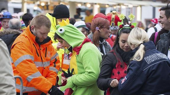 Agentes de Policía revisan las mochilas de varios participantes del carnaval de Colonia.