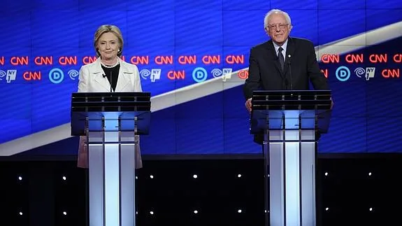 Los precandidatos demócratas Hillary Clinton (i) y Bernie Sanders participan en un debate televisado.