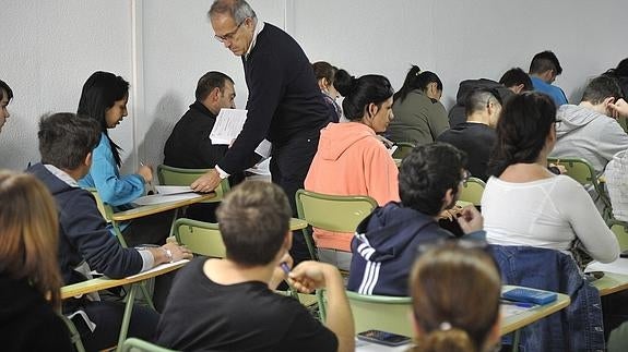 Un profesor reparte un examen.