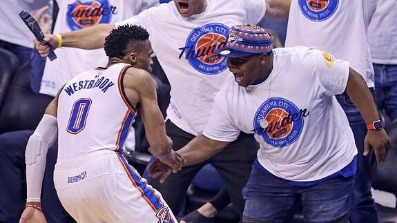 Westbrook celebra con un aficionado una canasta. 