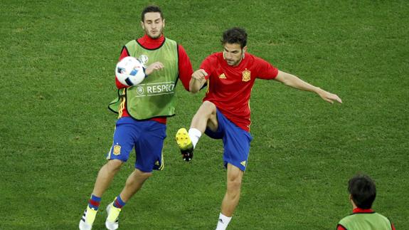 Koke y Cesc disputan un balón en el entrenamiento. 