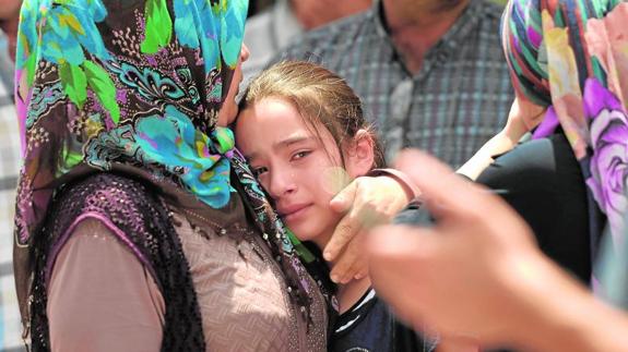 La hija de una de las víctimas es consolada por un familiar.