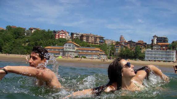 Una pareja disfrutando de un baño en la playa.