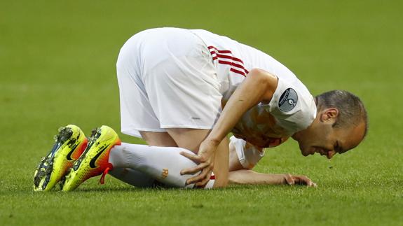 Andrés Iniesta cae dolorido durante un partido con la selección. 
