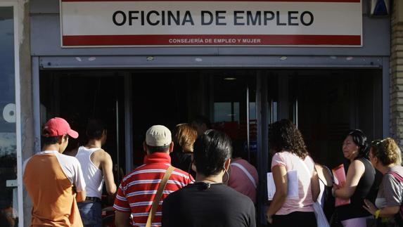 Desempleados hacen cola en una oficina del INEM de Madrid.