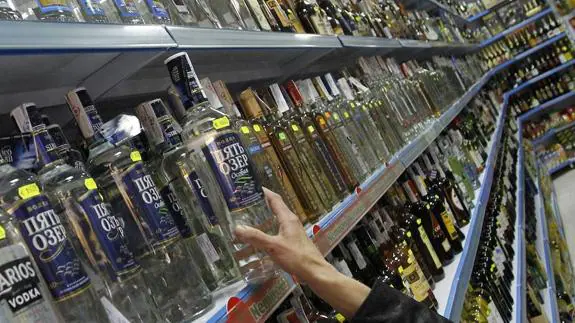 Mujer compra alcohol en un supermercado.