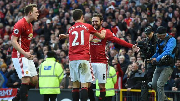 Ander Herrera felicita a Juan Mata delante de Phil Jones. 