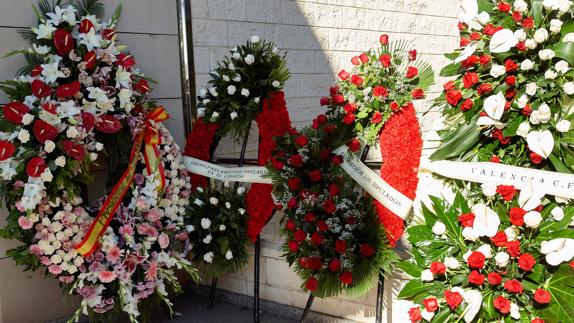 Varias coronas de flores apoyadas a las puerta del Tanatorio de Valencia.