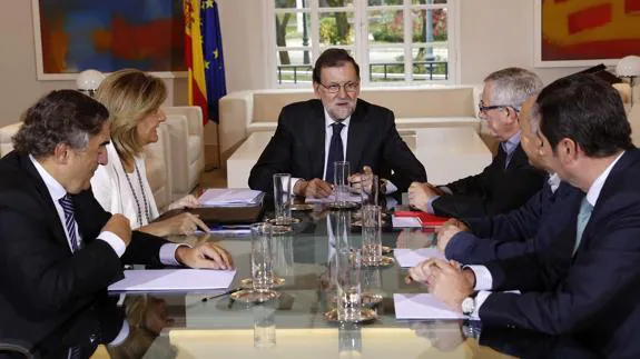 Mariano Rajoy, acompañado por la ministra de Empleo y los representantes de asociaciones empresariales y sindicatos.