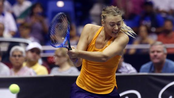 Maria Sharapova golpea la bola durante un partido de exhibición ante Mónica Puig. 