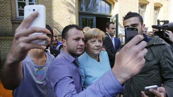 Anas Modamani (derecha) se saca una foto con Angela Merkel. 