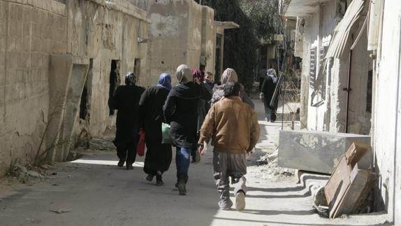 Varios familias caminan por las calles de Siria. 