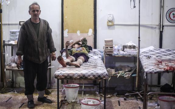 Un hombre junto a un niño herido en un hospital tras ataques aéreos ayer en Douma. 
