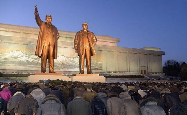 Ciudadanos norcoreanos se inclinan ante las estatuas de Kim Il-sung y Kim Jong-il.
