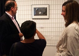 La presidenta de la AFV, Nuria Mongil , comentado una de las fotografías de la exposición con dos de los asistentes a la inauguración. / Fotos: C. Catalina