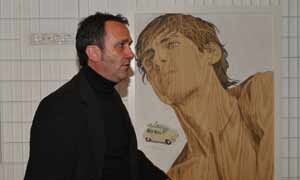 Juan Hernández junto a una de las obras pintadas sobre madera que pueden verse en la exposición ‘La mirada’ en Pedrajas de San Esteban. /C.Catalina