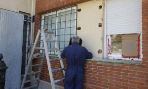 Un operario refuerza ayer las rejas de las ventanas por las que accedieron los ladrones. / J. Ruiz
