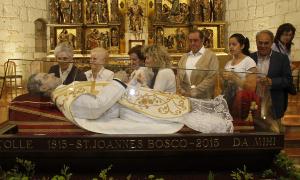 Varias personas observan la urna con los restos de San Juan Bosco. / E. Ruiz