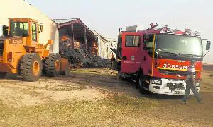 Los bomberos trabajan en la extinción del incendio declarado en las naves en Mayorga. . / P. Crespo