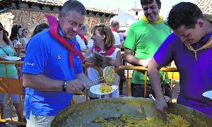 Los organizadores de la paella reparten las raciones en La Mota. / Marisa Franco