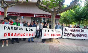 El Movimiento 15M, junto a varios colectivos sindicales, políticos y vecinales, se manifiestan ante la sede del Banco Popular en Cuatrovientos (León), contra el deshaucio de Laura Blanco, después de haberle concedido la dación en pago de su piso. / Ical.
