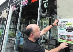 César Díaz coloca el cartel del 'tándem' en su establecimiento. / Henar Sastre