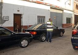 Un agente del Cuerpo Nacional de Policía realiza una inspección ocular en la calle del suceso./ Fran Jiménez