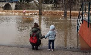 Una madre observa con su hija la crecida del Cega en Viana. / HENAR SASTRE