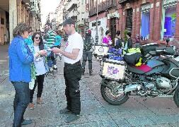 'El motero solidario' entrega una octavilla a dos mujeres en la Calle Mayor. / Antonio Quintero