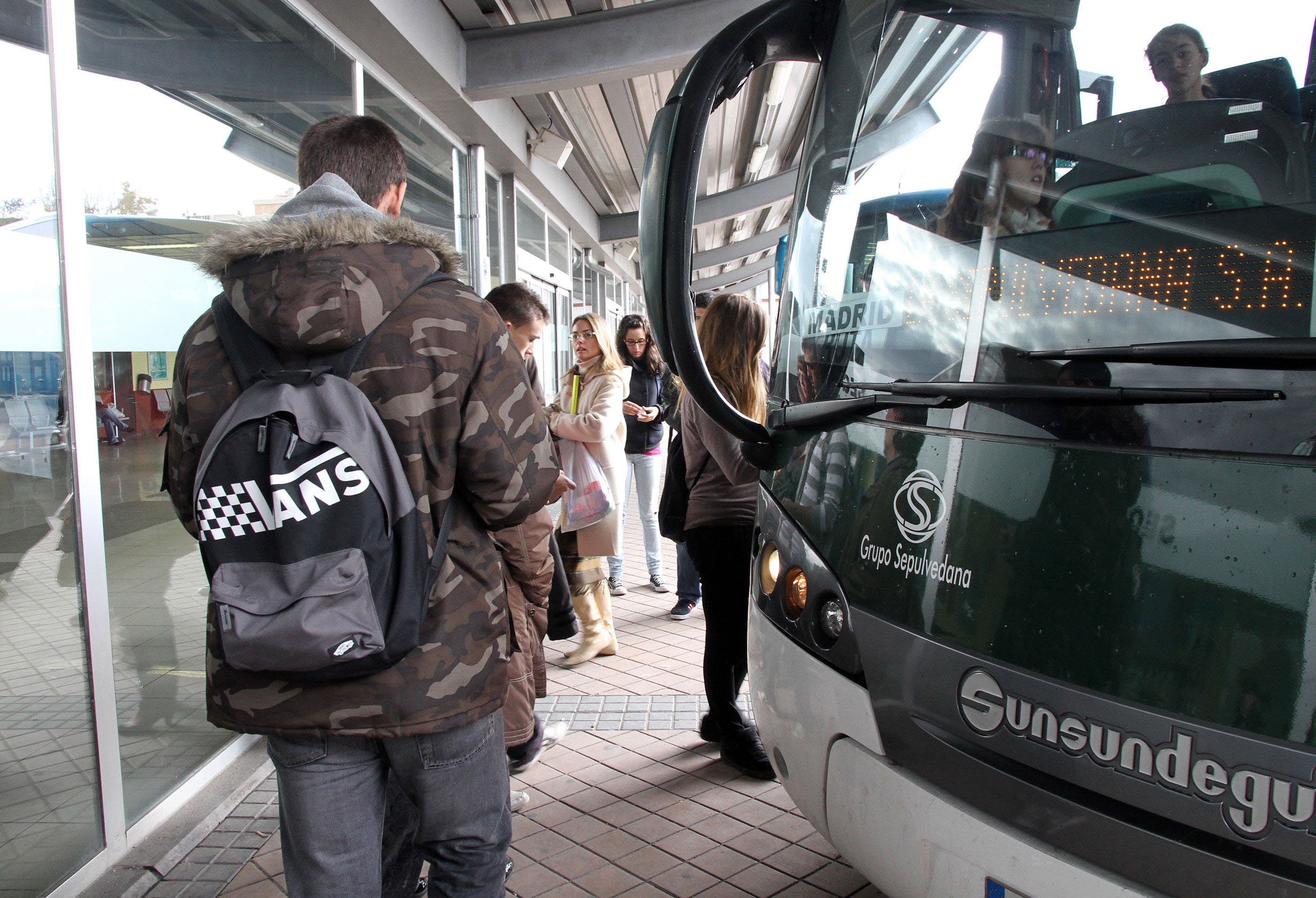 Usuarios del servicio de transporte por carretera a Madrid se suben a un autobús Segovia-Madrid. 