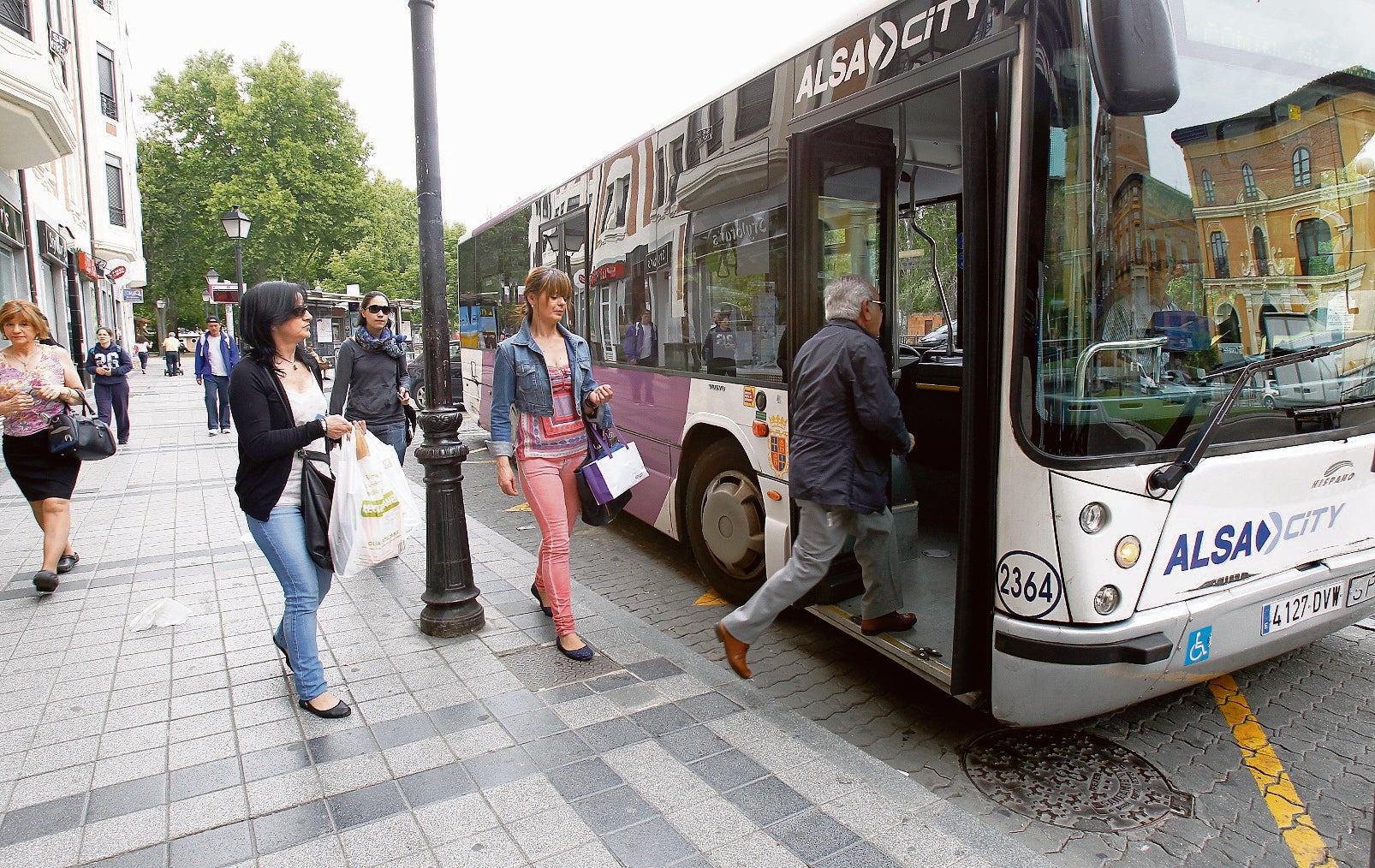 Algunos usuarios se disponen a subir a uno de los autobuses urbanos, en la plaza de León. M. de la fuente