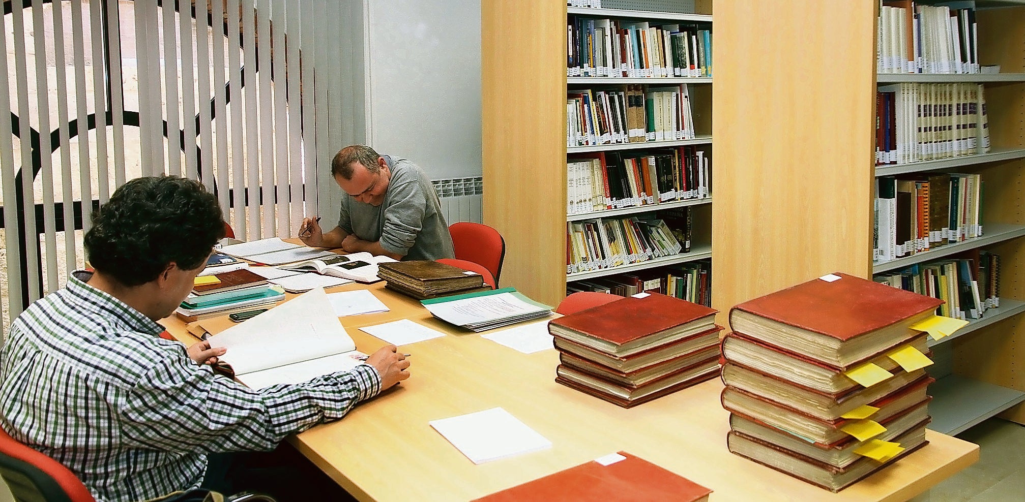 Dos investigadores consultan documentos del archivo de la Diputación, ubicado en el castillo de Fuentes de Valdepero.