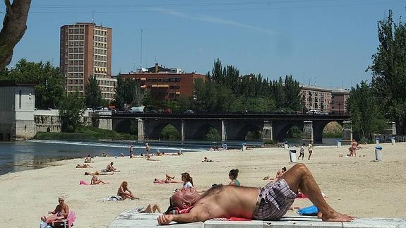 Varios vallisoletanos toman ya estos días el sol en la Playa de las Moreras, punto de encuentro de la ciudad durante los meses más cálidos. 