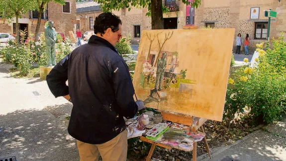 Uno de los artistas participantes plasma ayer la figura de Javier Cortes en su cuadro.