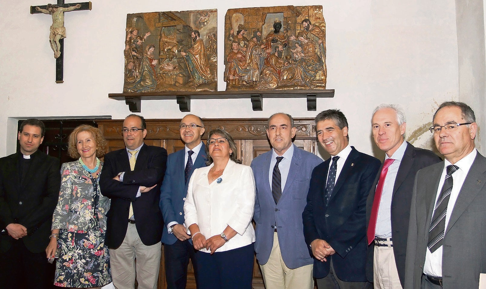 Representantes políticos y religiosos posan ante los dos relieves.