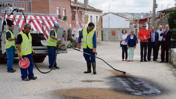 El presidente de la Diputación, a la derecha, con representantes de la institución provincial y del Ayuntamiento de Población, observan las obras de bacheo en la localidad. 