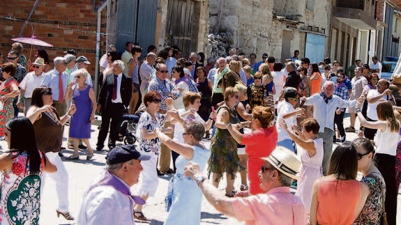 Numerosos vecinos de Cevico Navero bailan al paso de la patrona de la localidad, durante la festividad celebrada este miércoles. 