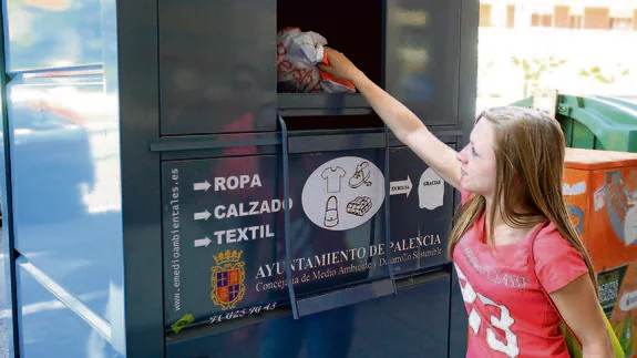 Una mujer utiliza este miércoles el contenedor de ropa instalado en la avenida Modesto Lafuente. 