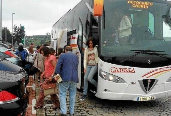 Varios pasajeros descienden del autobús que les llevó de la estación de Aguilar a la de Torrelavega.