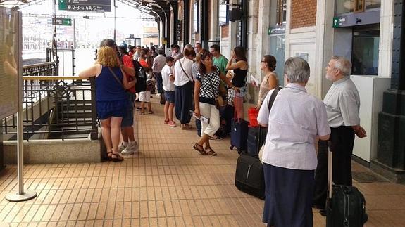 Viajeros con destino a Madrid y Alicante, esperan la llegada de un tren Alvia detenido en Cabezón. 