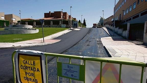 Una valla indica que una calle está cortada por la renovación del asfaltado.
