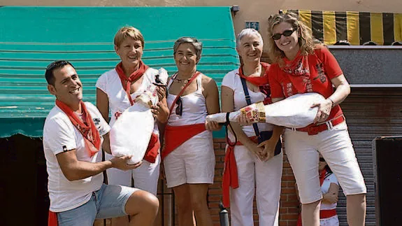 Diego Sanz Gamarra y Elena Herrero Román sujetan los jamones que ganaron ayer en el concurso de bebedores en bota de Pedrajas