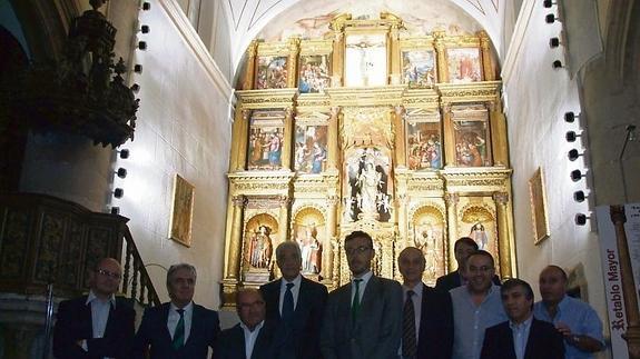 Autoridades y responsables de Iberdrola posan delante del retablo iluminado.