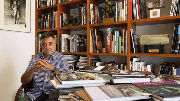 Gervasio Sánchez posa en su despacho frente a una mesa repleta de libros de Guerra.